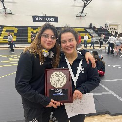 Two female wrestlers pose after winning the 5A Regional Championship